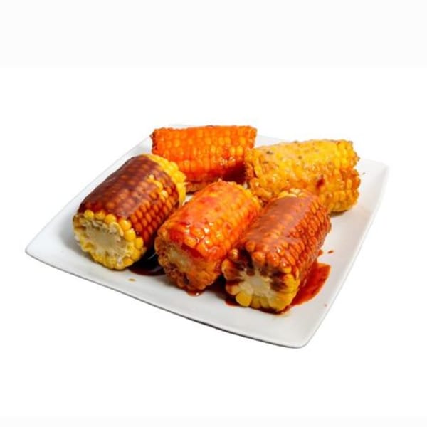 Five pieces of corn on the cob, some with barbecue sauce, on a white rectangular plate.