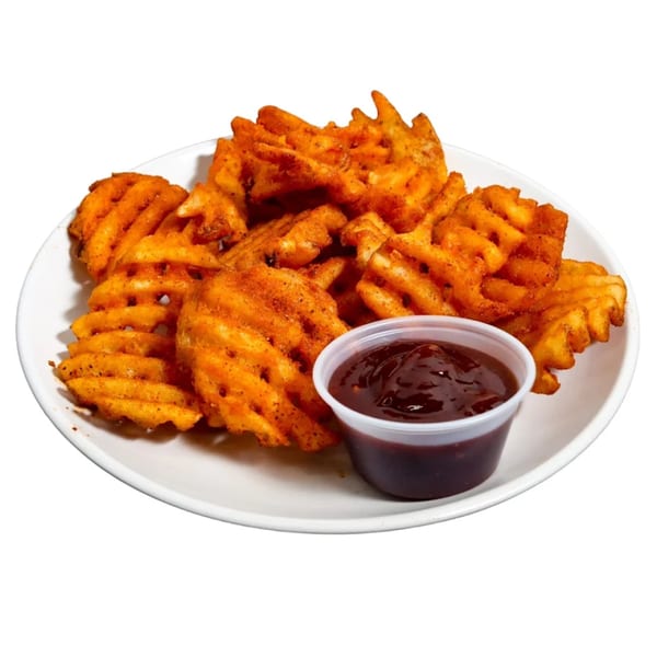 A white plate piled high with seasoned waffle fries and a side of barbecue sauce.